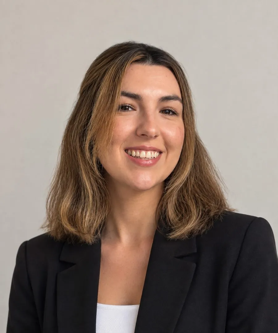 Portrait of Maria Latorre, smiling, wearing a black blazer